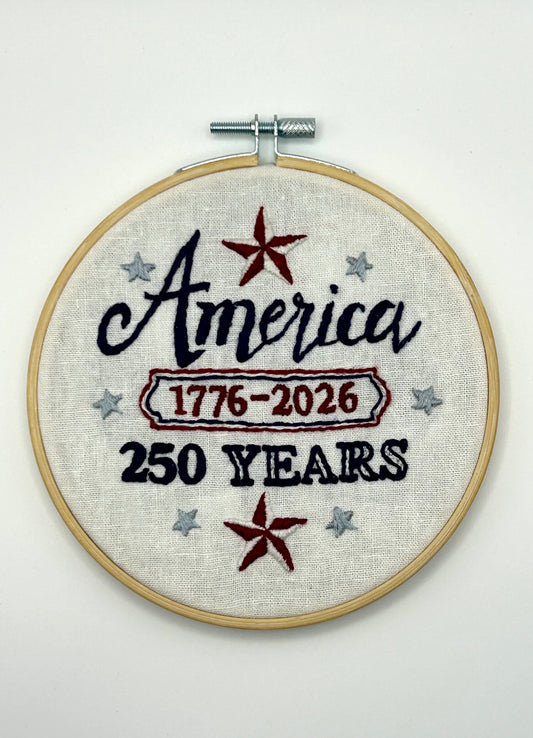 Embroidery Kit with 'America 1776-2026 250 Years' text and stars on a white background designed by Deb Strain.